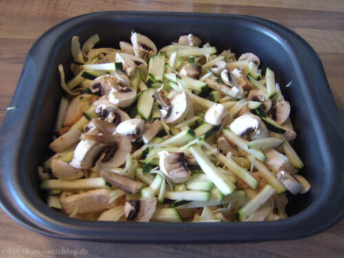 Zucchini und Champignons in die Form schichten